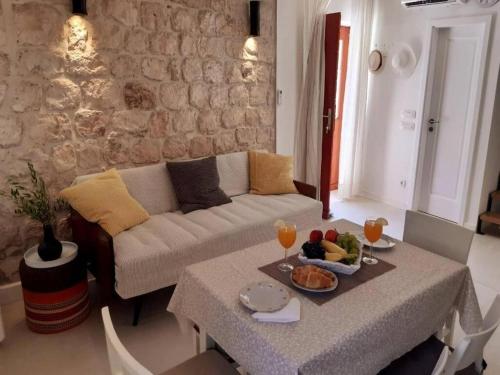 uma sala de estar com um sofá e uma mesa com comida em Casa Ruben, private stone house em Vis