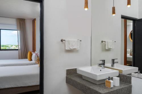 a white bathroom with a sink and a bed at Balkon Boutique Hotel in Playa del Carmen