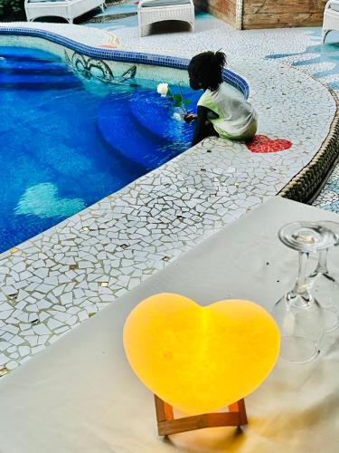 a yellow heart chair sitting next to a swimming pool at Maison du Bonheur in Dakar