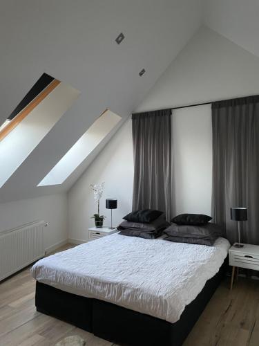 een slaapkamer met een groot bed op zolder bij Verblijf in loft van luxe villa de Vossenberg in Etten-Leur