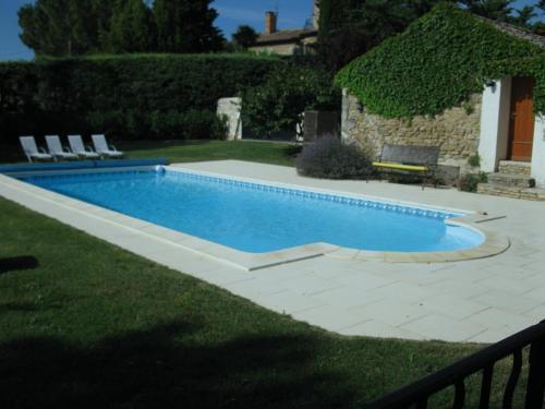 une piscine dans une cour avec des chaises autour dans l'établissement La Méjanenque, à Vénéjan