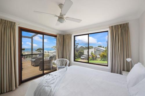 a bedroom with a bed and a large window at Kelton Beach Haven in Mollymook