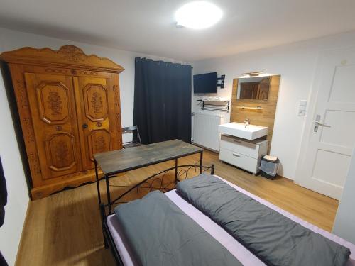 um quarto com uma cama, uma secretária e um lavatório. em Loisachtalerhof em Grainau