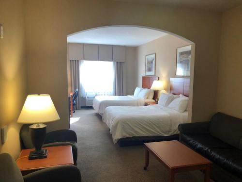 a hotel room with two beds and a couch at Holiday Inn Express Hotel & Suites Howell by IHG in Howell