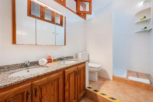a bathroom with two sinks and a toilet at Anita Apartments in Port de Pollensa