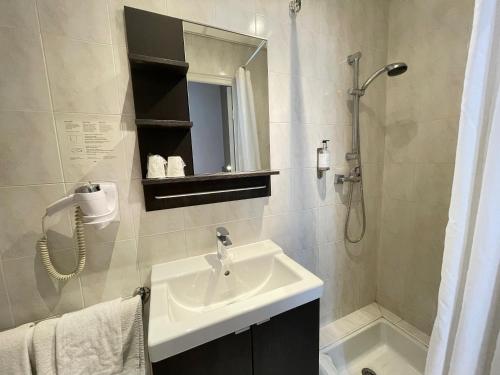 a bathroom with a sink and a shower at Hotel de La Comédie in Montpellier