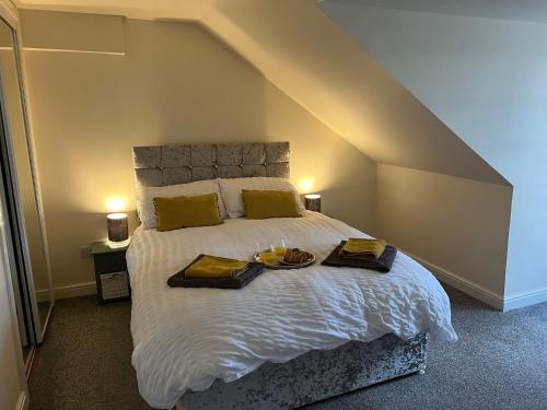 a bedroom with a large bed with two plates on it at Ayr Loft Apartment with Fabulous Views in Ayr