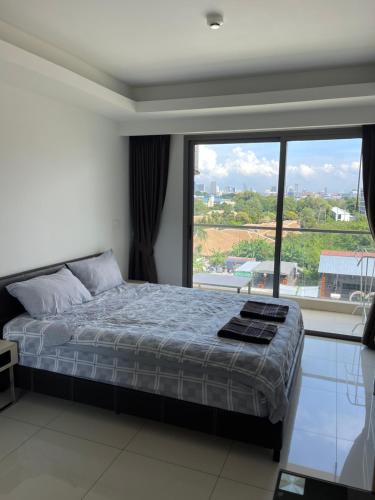 ein Schlafzimmer mit einem Bett und einem großen Fenster in der Unterkunft Laguna Beach Resort 2 in Jomtien Beach