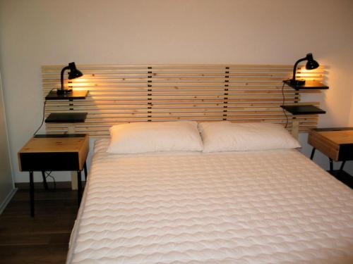 - une chambre avec un grand lit blanc et deux lampes dans l'établissement Boost Your Immo Bois De Marie Barèges PM9, à Barèges