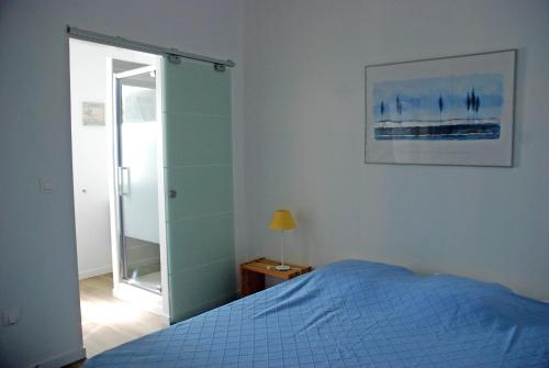 sypialnia z niebieskim łóżkiem i lustrem w obiekcie Le Mas de la Palmeraie - Appartement dans propriété privée au calme avec piscine et tennis w mieście Bormes-les-Mimosas