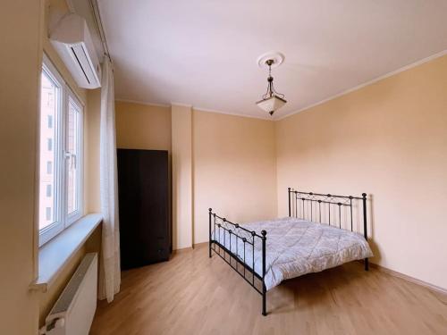 une chambre avec un lit dans une pièce avec une fenêtre dans l'établissement Аппартамент Мтацминда, à Tbilissi