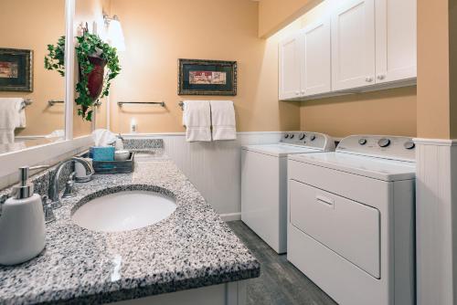 a bathroom with a sink and a washer and dryer at stayNantahala - Smoky Mountain Cabins in Aquone
