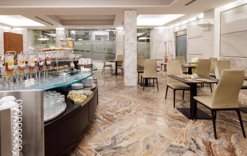 a restaurant with tables and chairs and a buffet at Best Western Plus Hotel Universo in Rome