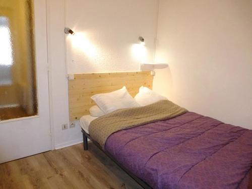 ein Schlafzimmer mit einem Bett mit einer lila Decke in der Unterkunft Boost Your Immo Artigalas Barèges PM11 in Barèges