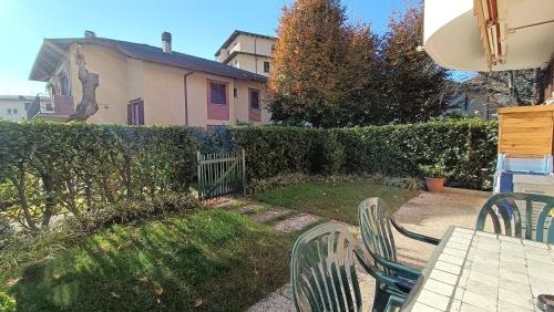 um quintal com uma mesa e cadeiras e uma cerca em House in a beautiful residence with garden, swimming pool and parking spot - Larihome A07 em Domaso
