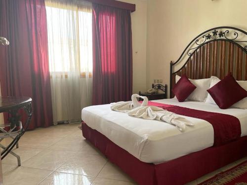 a hotel room with two beds with red curtains at Perla Hôtel in Fès