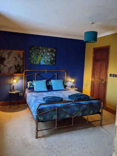 a bedroom with a bed with a blue wall at Farmhouse B&B Family stay or Romantic break, on our smallholding close to Narberth in Narberth