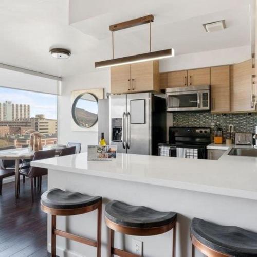 a kitchen with a large white counter and stools at Panorama Place in Reno