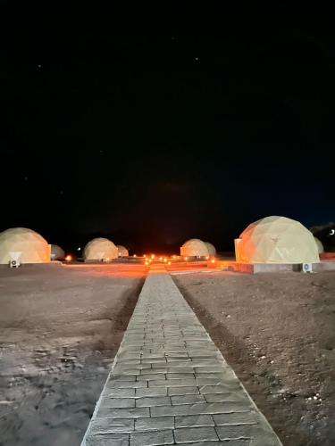 an empty parking lot at night with domes at Nara Wadi RUM Camp in Wadi Rum