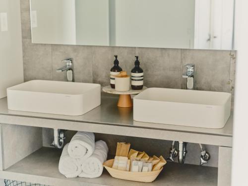 Baño con 2 lavabos y toallas en un estante en Playliving IZU - A ocean view villa with Onsen, en Ito