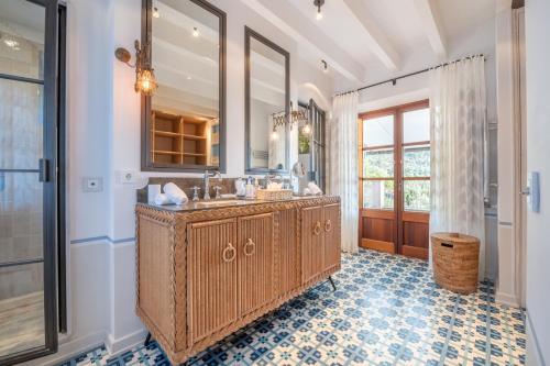 a bathroom with a double sink and a large mirror at Villa Rafam - Deia in Deia