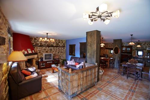 a large living room with a stone wall at Posada Rural Ochohermanas in Las Fraguas