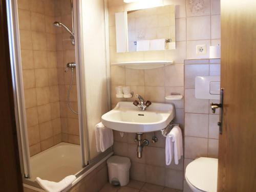 a small bathroom with a sink and a shower at Gasthof Pension Madseiterhof in Tux