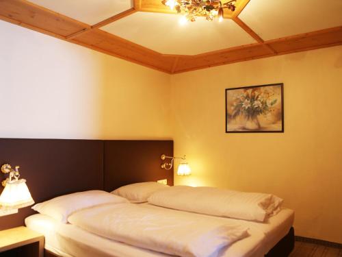 a bedroom with two beds and a ceiling at Gasthof Pension Madseiterhof in Tux