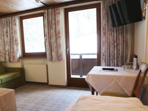 a dining room with a table and two windows at Gasthof Pension Madseiterhof in Tux