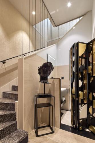 a statue of a cat sitting on a table next to a staircase at Maison Albar - Le Pont-Neuf in Paris