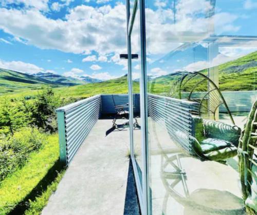 a balcony with a chair and a view of the hills at Hidden Cottages in Kvíabekkur