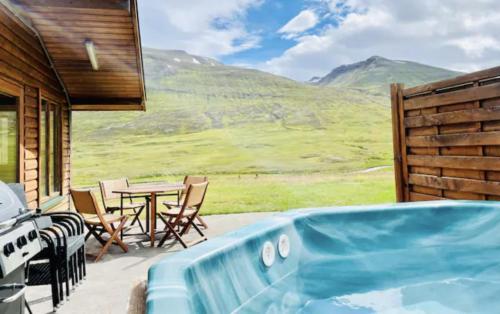 a hot tub on a patio with a table and chairs at Hidden Cottages 