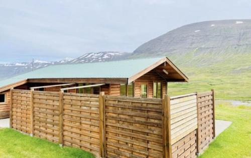 a wooden house with a fence in front of it at Hidden Cottages in Kvíabekkur
