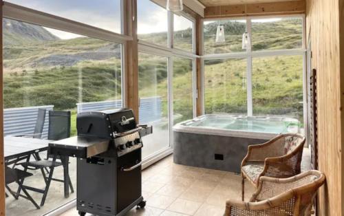 a room with a tub and a table and chairs at Hidden Cottages in Kvíabekkur