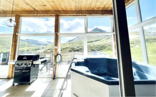 a kitchen with a view of a mountain range through a window at Hidden Cottages 