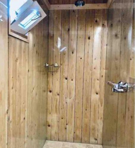 a bathroom with a wooden wall with a shower at Hidden Cottages in Kvíabekkur