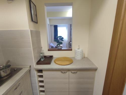 a small kitchen with a sink and a mirror at Suncani apartman 36, Brzece in Brzeće