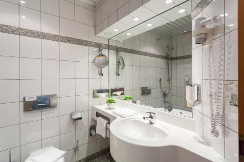 a white bathroom with a sink and a mirror at Hotel Neustädter Hof in Schwarzenberg