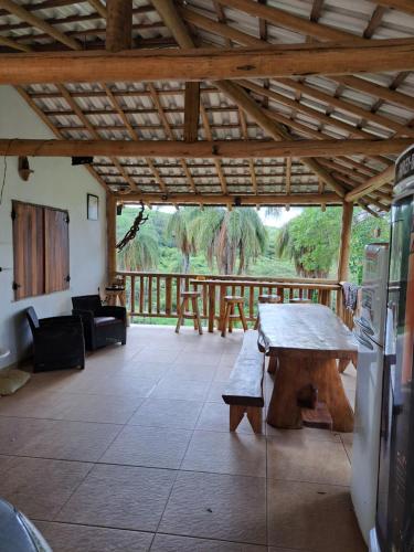 ein Wohnzimmer mit einem Tisch und einer Holzdecke in der Unterkunft Pousada Sempre Luz in Santana do Riacho