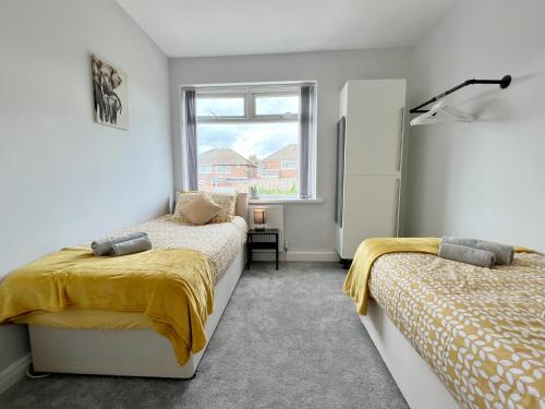 1 dormitorio con 2 camas y ventana en Cheerful 3 bedroom home with Netflix and Wi-Fi, en Middleton