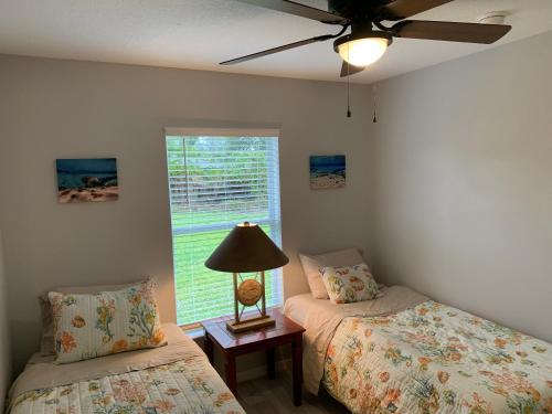 a bedroom with two beds and a window at Salty Kisses in Palm Bay