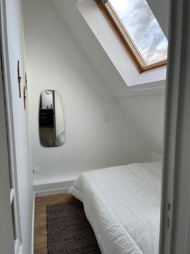 une chambre avec un lit et un miroir au mur dans l'établissement Le426, Charmant F2 refait à neuf, à Mouvaux