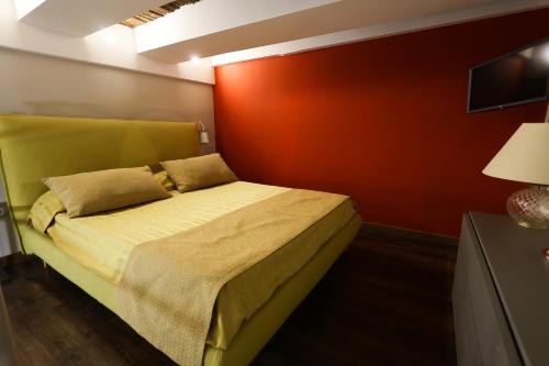 ein Schlafzimmer mit einem Bett mit einer roten Wand in der Unterkunft IL BASSO ACCOMODATION in Neapel