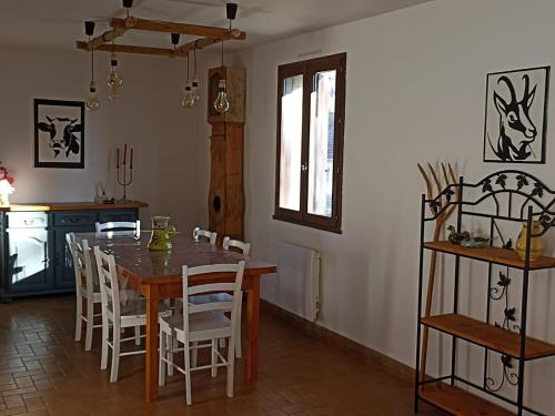une cuisine et une salle à manger avec une table et des chaises en bois dans l'établissement Les rives du Drac, à Chabottes