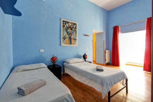 ローマにあるRoman Houseの青い壁のドミトリールーム ベッド2台