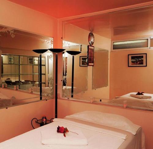 een slaapkamer met een bed en een grote spiegel bij Perla Hôtel in Fès
