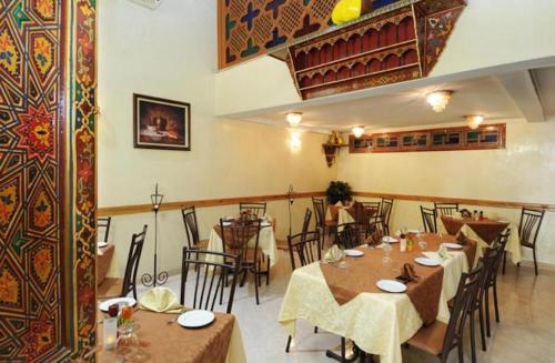 ein Restaurant mit Tischen und Stühlen in einem Zimmer in der Unterkunft Perla Hôtel in Fès