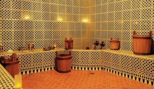 a bathroom with white tiled walls and brown pots at Perla Hôtel in Fès