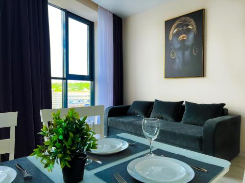 a living room with a couch and a table at Dendrarium Park, 1BD apartment with living room in Chişinău