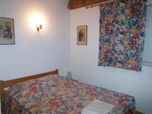 a bedroom with a bed with a colorful comforter at Le Râteau Bavoir in Calvi